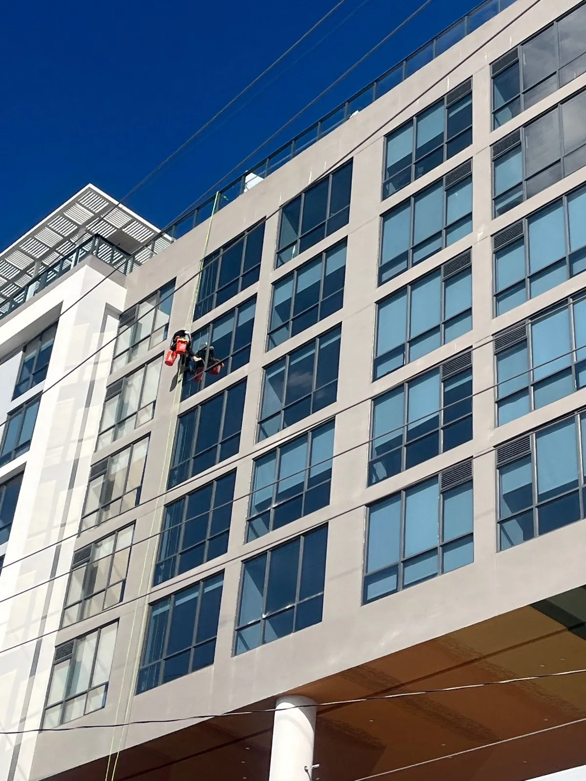 Rope-access crew painting the FB Wynwood facade